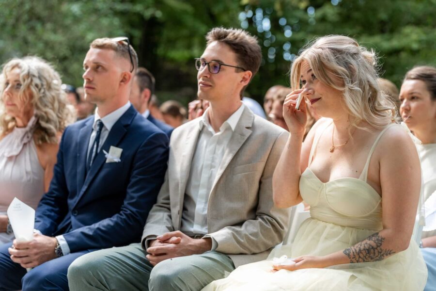 Gäste bei emotionaler Hochzeitszeremonie im Freien