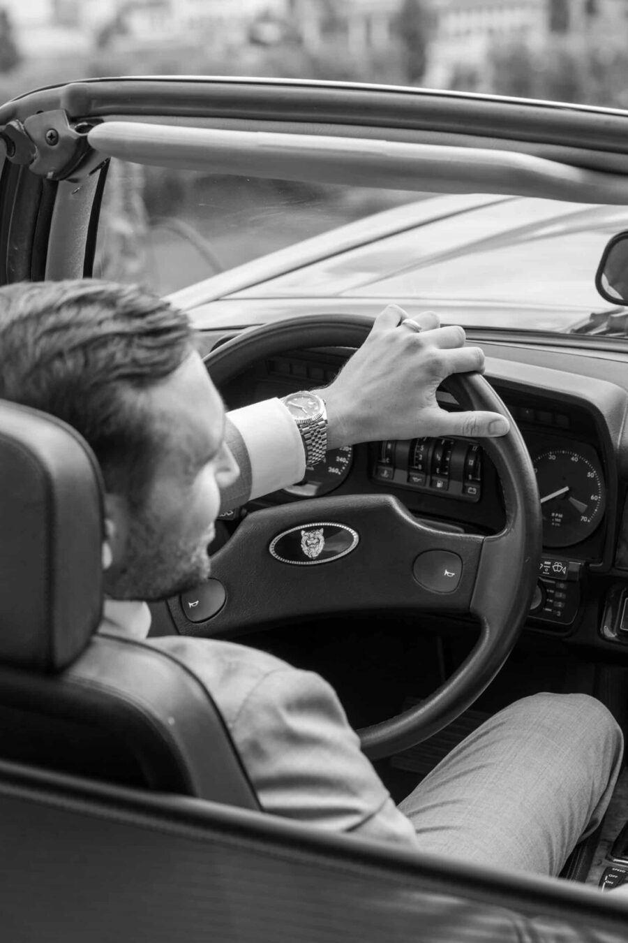 Mann in Cabrio fährt zur Hochzeitslocation