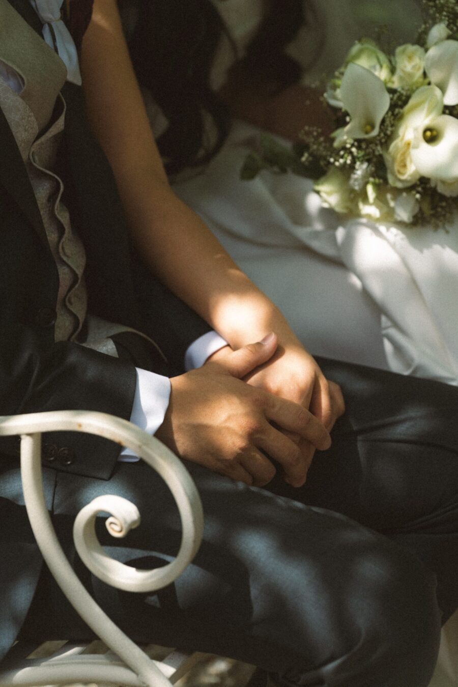 Brautpaar hält Hände mit Blumenstrauß