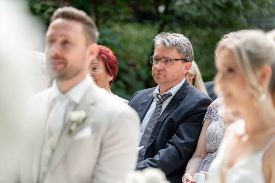 Gäste bei Hochzeitszeremonie im Garten