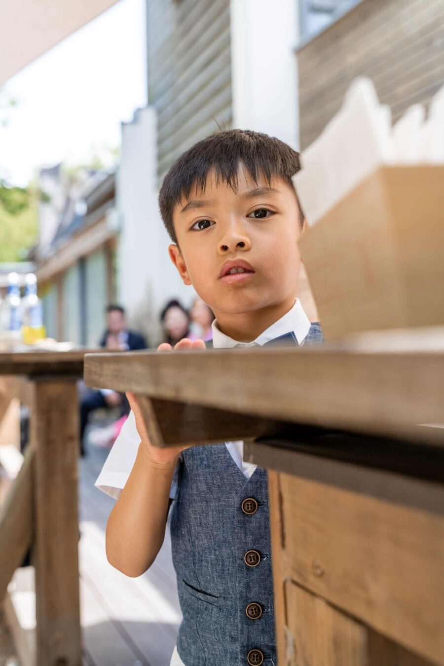 Kind bei Hochzeitsfeier am Holztisch.