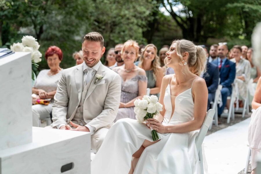 Brautpaar lächelt bei Outdoor-Trauung im Garten