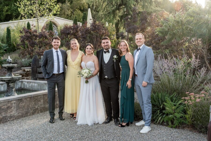 Hochzeitsgäste posieren im Garten bei der Feier.