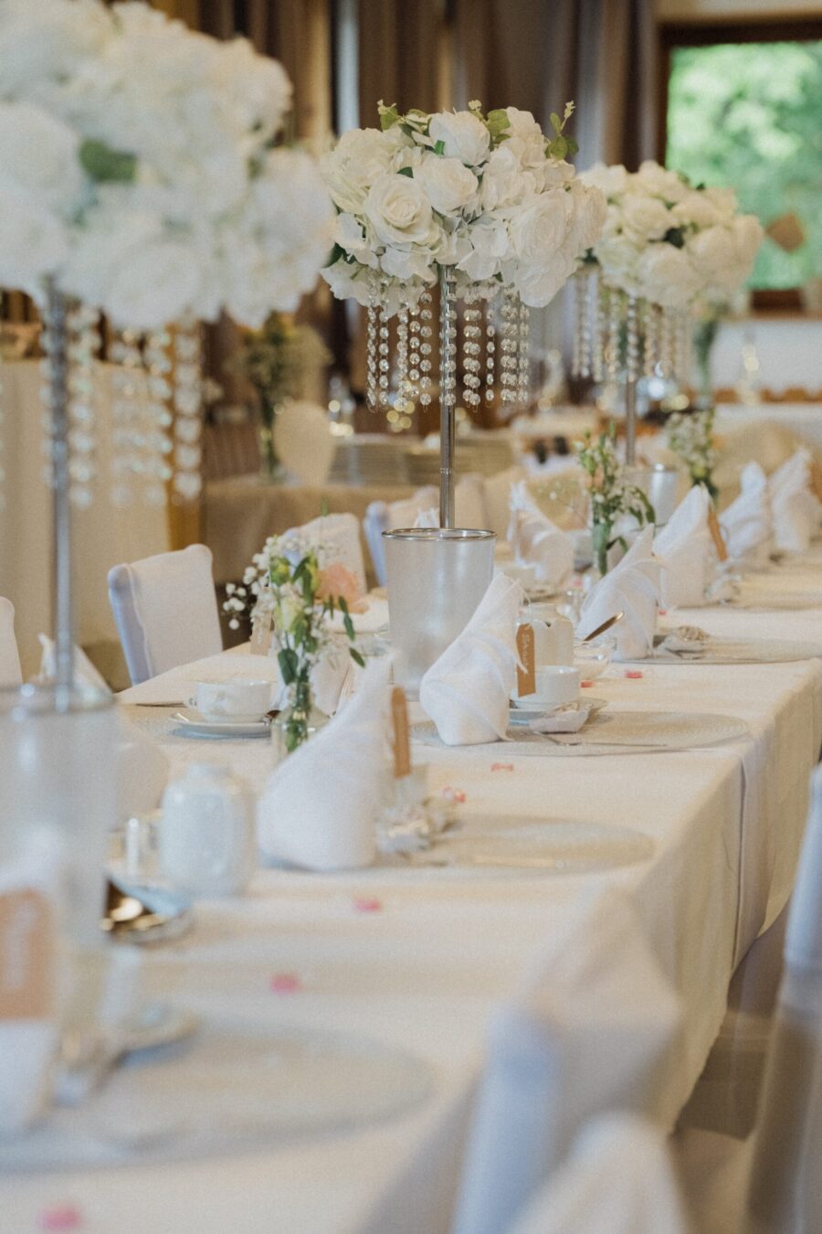 Hochzeitsgedeck mit weißen Blumenarrangements