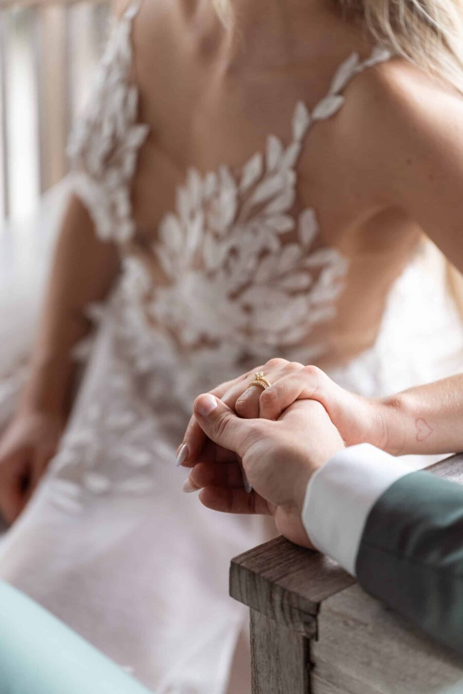 Hände des Brautpaars mit Ring und Tattoo