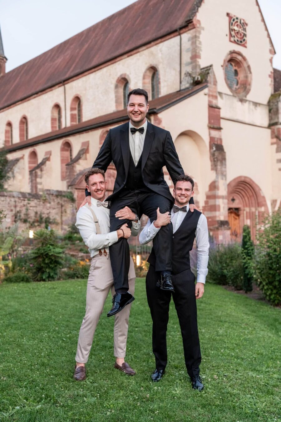 Gäste posieren vor historischer Kirche im Freien