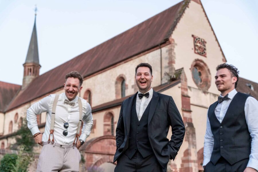 Gäste lachen vor historischer Kirchenkulisse