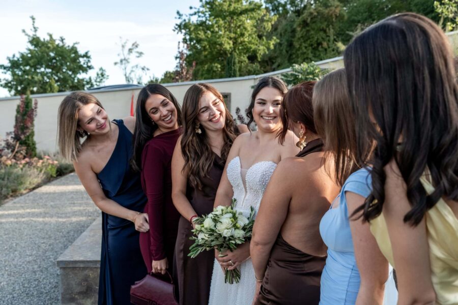 Braut mit Freundinnen im Garten bei Hochzeit