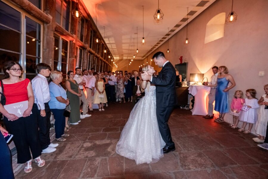 Lieder erster Hochzeitstanz Brautpaar tanzt in rustikalem Hochzeitssaal