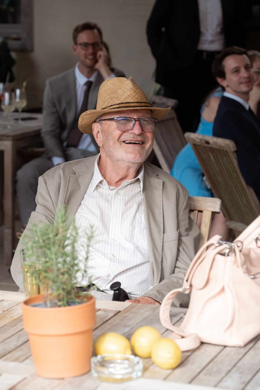 Älterer Hochzeitsgast lächelt im Garten