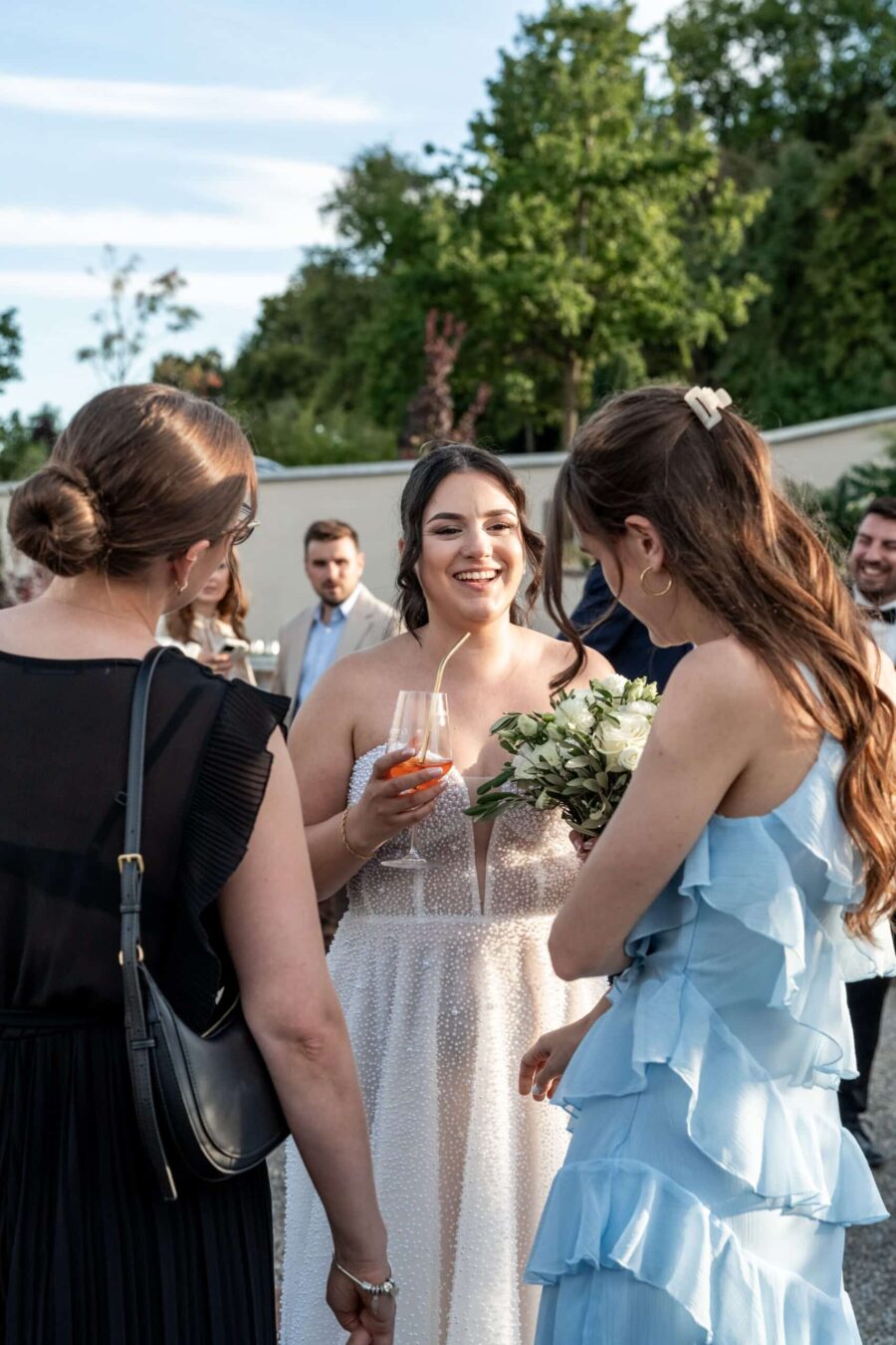 Braut im Gespräch mit Gästen im Sommergarten
