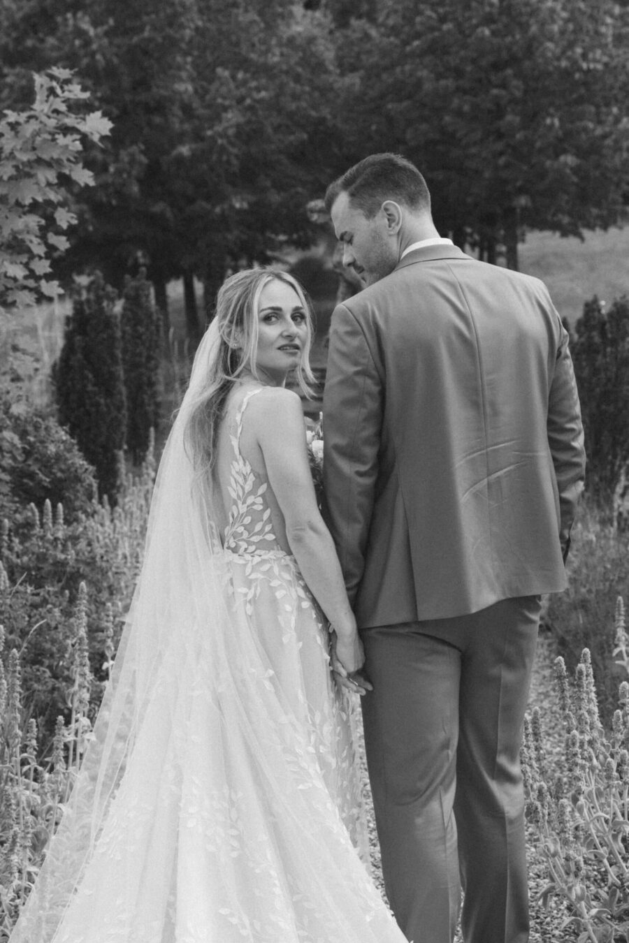 Brautpaar im Garten, schwarz-weiß Foto.