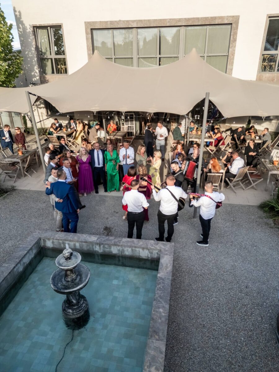 Hochzeitsgäste feiern im Garten mit Musikerquartett.