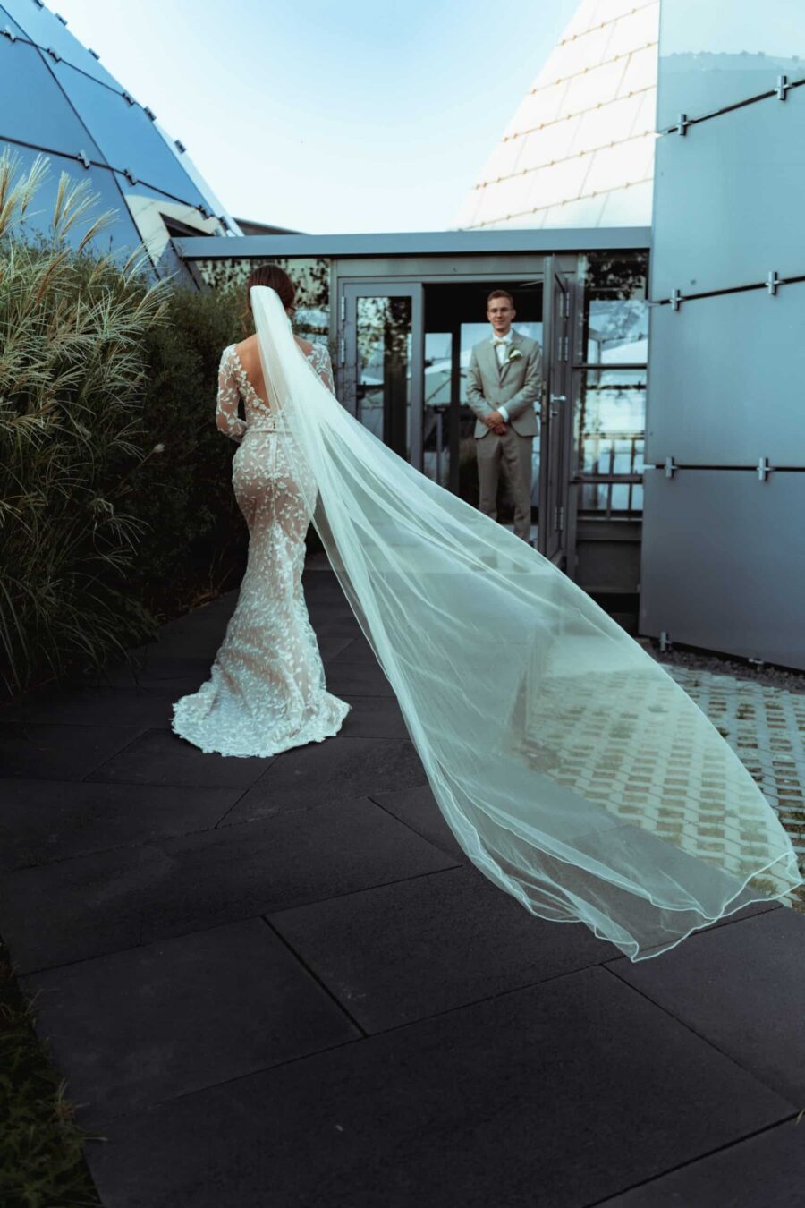 Braut im eleganten Kleid geht zum Bräutigam