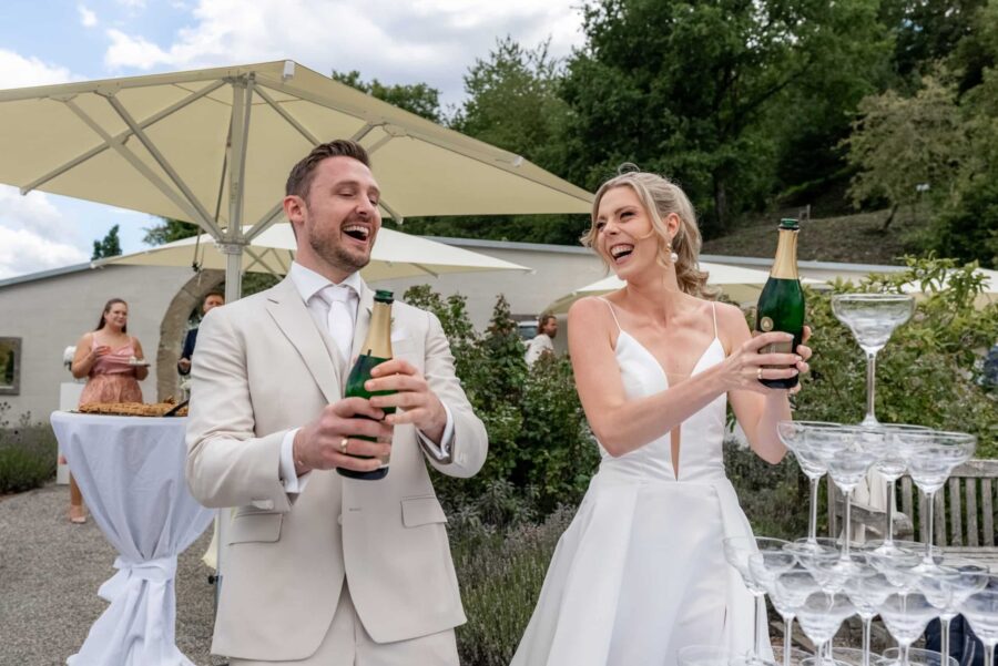 Hochzeit Villa Oriental | Editorial Summer Vibes & Live Cooking 129 Champagnerkorken knallen, Brautpaar beim Sektempfang