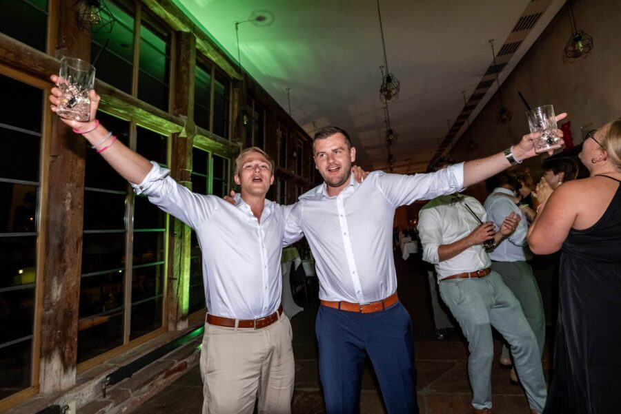 Jubelnde Hochzeitsparty mit Gästen im Festsaal