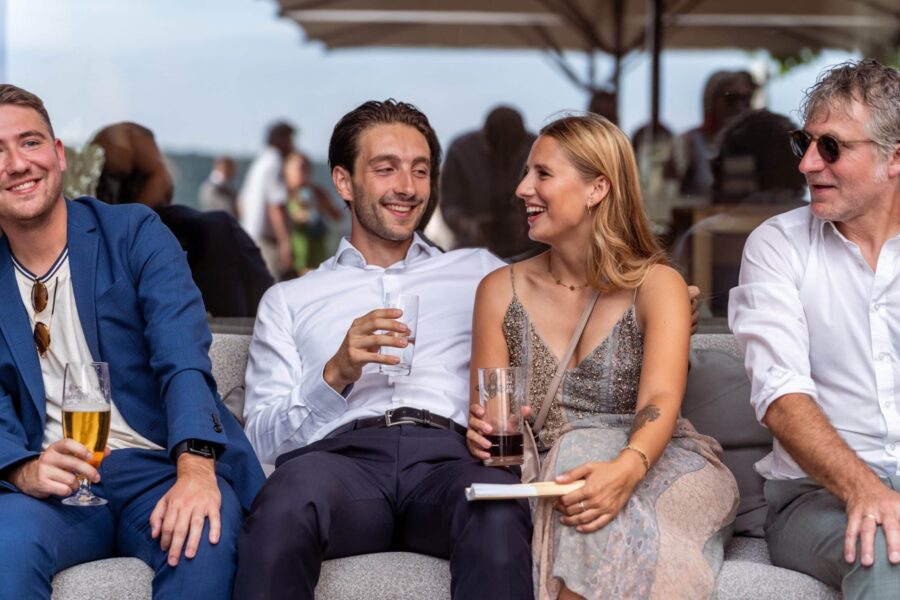 Gäste sitzen entspannt bei Hochzeitsfeier im Freien