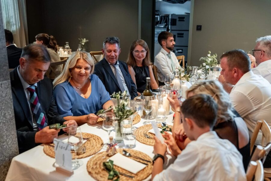 Gäste bei festlichem Hochzeitsessen am Tisch