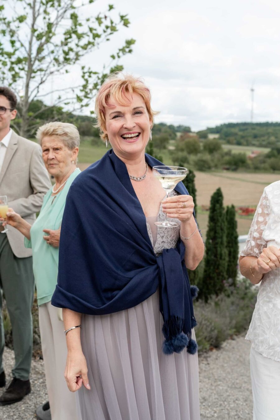 Elegante Hochzeitsgäste im Freien feiern.