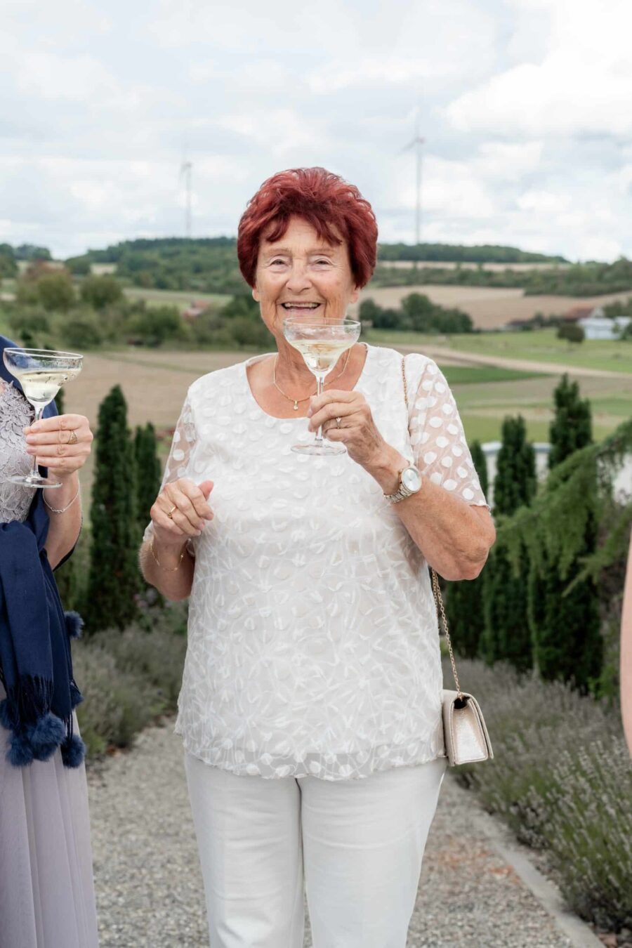 Gäste genießen Sekt bei Hochzeit im Freien