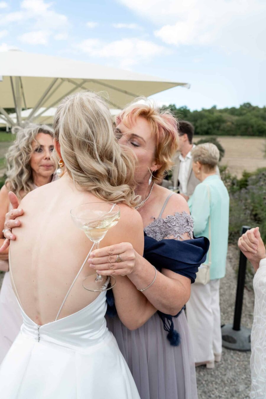 Hochzeit Villa Oriental | Editorial Summer Vibes & Live Cooking 411 Umarmung bei Hochzeitsempfang im Freien