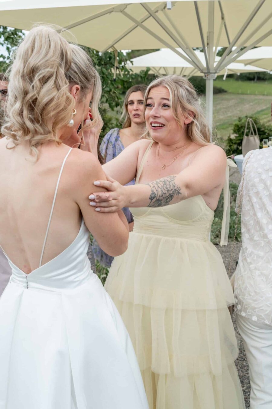 Gäste begrüßen Braut im Sommergarten