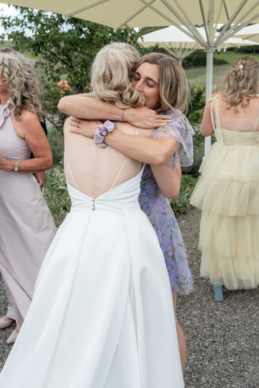Umarmung von Hochzeitsgästen im Sommergarten