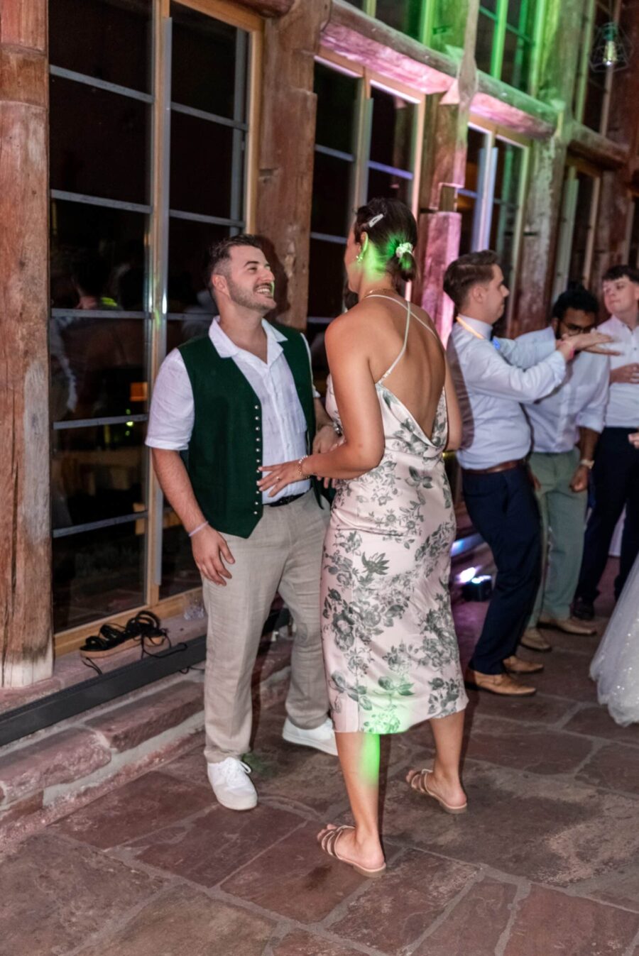Gäste tanzen drinnen bei Hochzeitsfeier