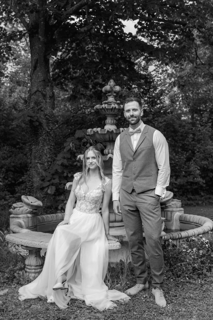 Brautpaar im Garten vor antikem Brunnen