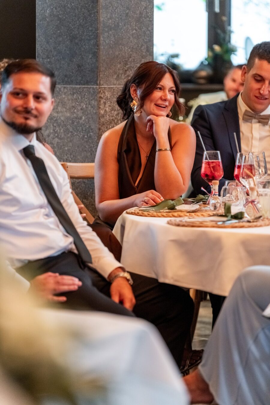 Gäste sitzen bei Hochzeit am festlichen Tisch.