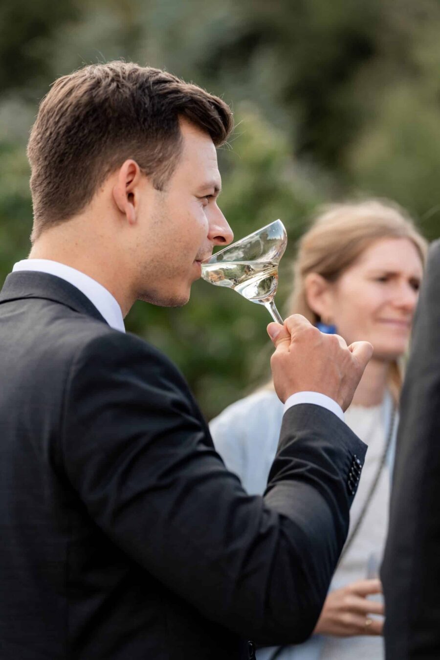 Hochzeit Villa Oriental | Editorial Summer Vibes & Live Cooking 422 Gast mit Champagnerglas bei Hochzeitsempfang im Garten