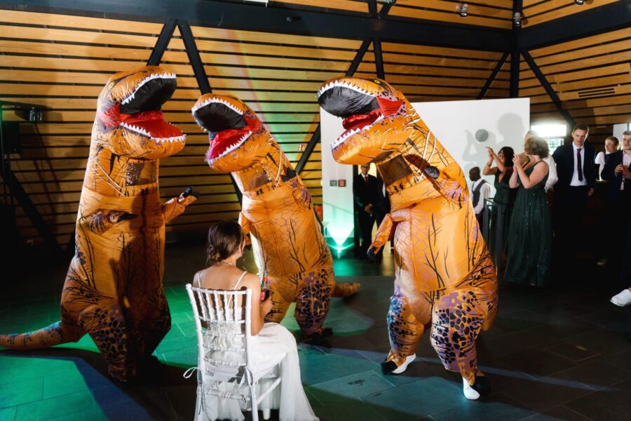 Braut mit Dinosaurierkostümen bei Hochzeitsfeier