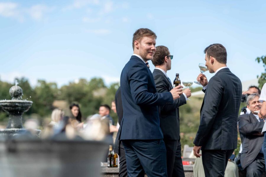Hochzeit Villa Oriental | Editorial Summer Vibes & Live Cooking 152 Gäste im Anzug mit Getränken im Freien