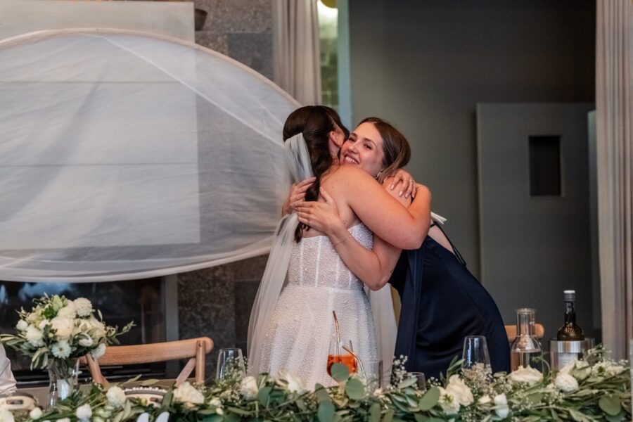 Umarmung bei der Hochzeit am dekorierten Tisch
