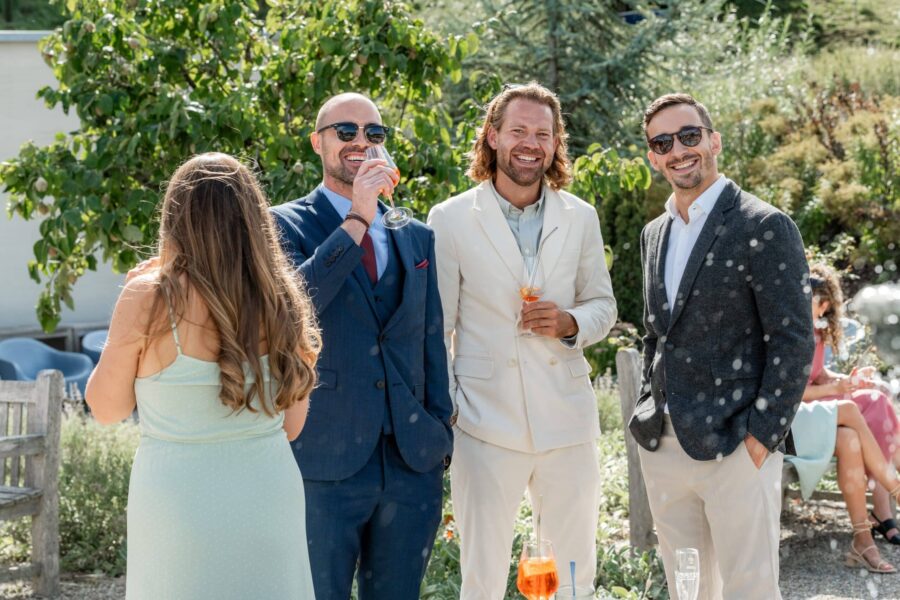 Gäste im Garten mit Getränken an Hochzeitstag