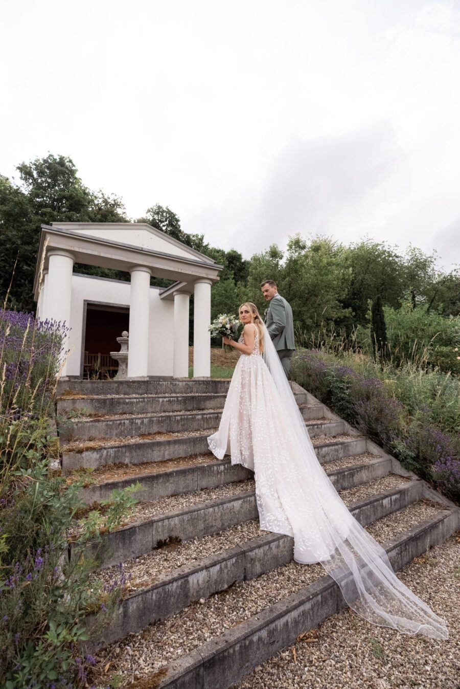 Brautpaar auf Treppe vor Gartenpavillon
