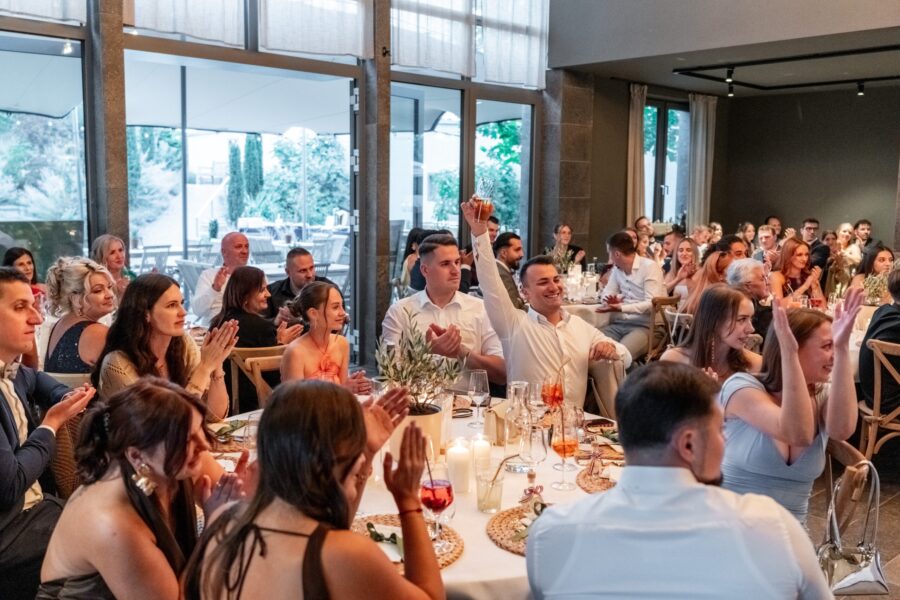Gäste applaudieren bei Hochzeitsfeier in festlichem Saal