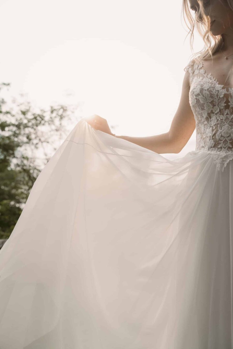 Braut in Spitzenkleid im Sonnenlicht