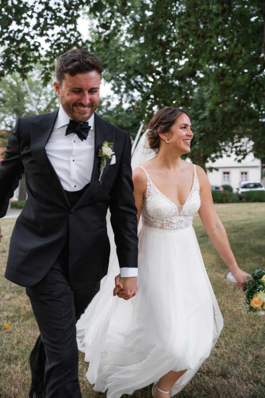 Brautpaar spaziert glücklich im Garten