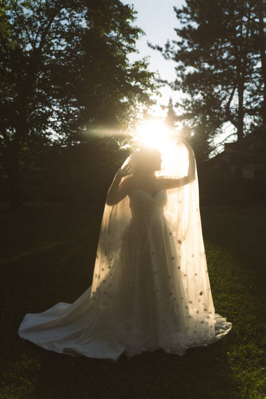 Braut im Sonnenlicht mit Schleier im Garten Hofgut Hünersdorff