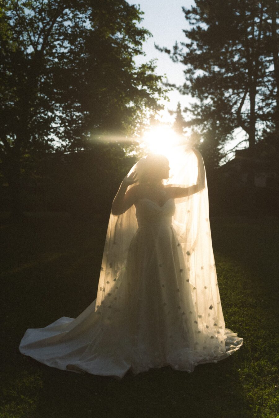Braut im Sonnenuntergang mit Schleier im Garten Hofgut Hünersdorff