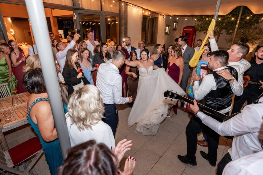 Hochzeitsfeier mit tanzendem Brautpaar und Gästen