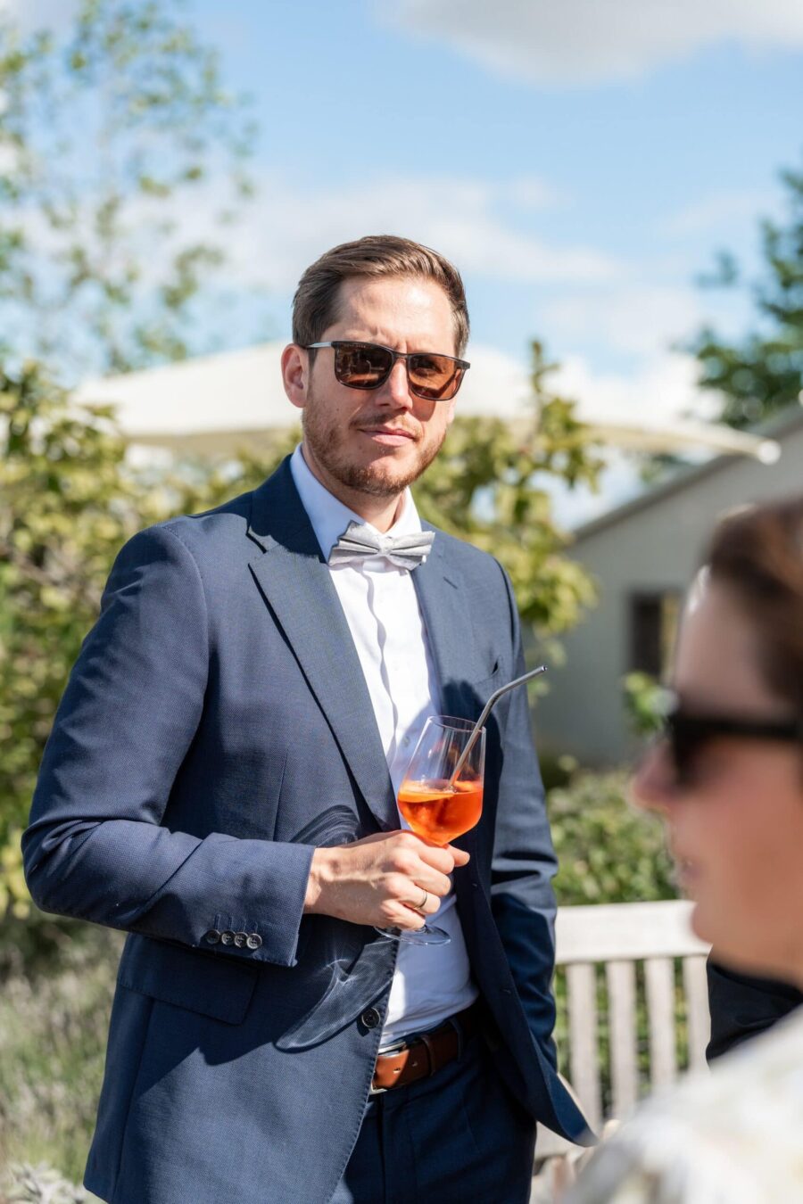 Hochzeitsgast mit Cocktail im Garten