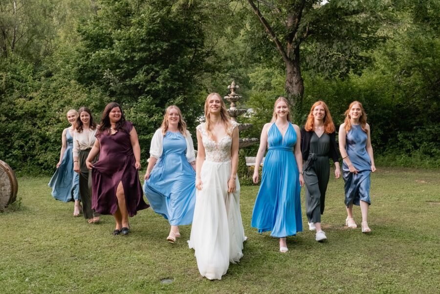 Braut und Brautjungfern im Garten vor Brunnen