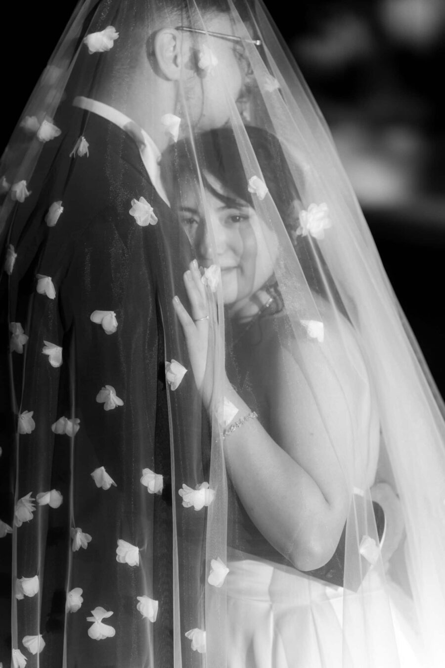 Brautpaar unter Blumenschleier umarmt sich, Hofgut Hünersdorff