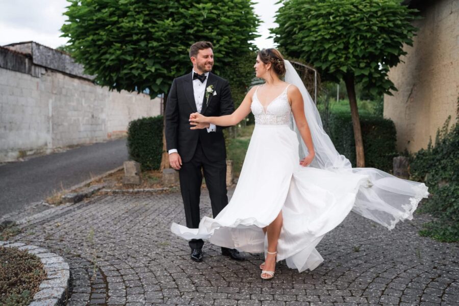 Brautpaar tanzt auf Kopfsteinpflasterweg
