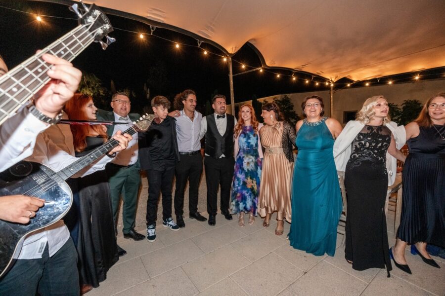 Hochzeitsgäste tanzen und feiern unter Lichterkette