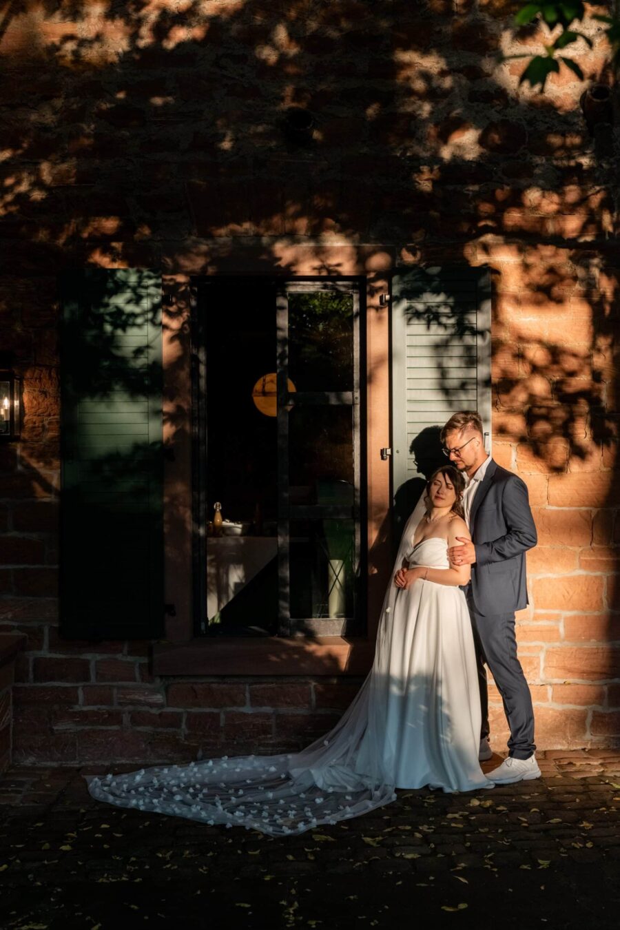 Brautpaar vor Backsteinwand im Abendlicht. Hofgut Hünersdorff