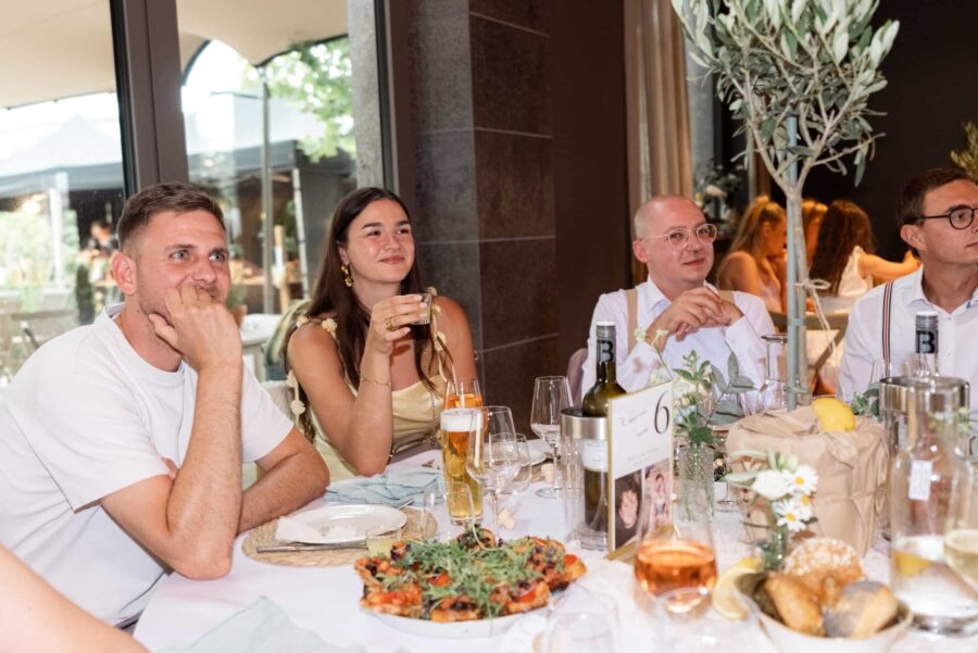 Gäste am Tisch bei Hochzeitsempfang innen