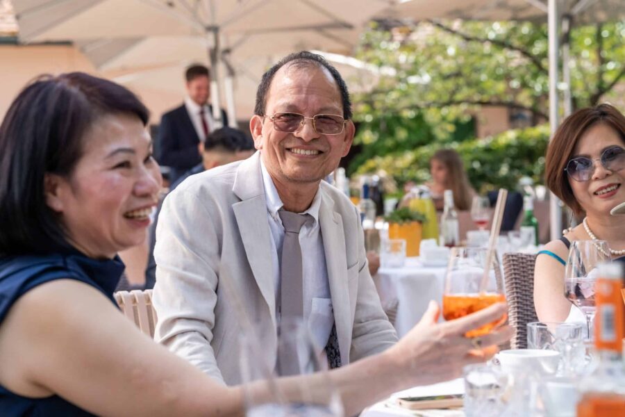 Hochzeitsgäste am Tisch im Garten bei Sommerfest.